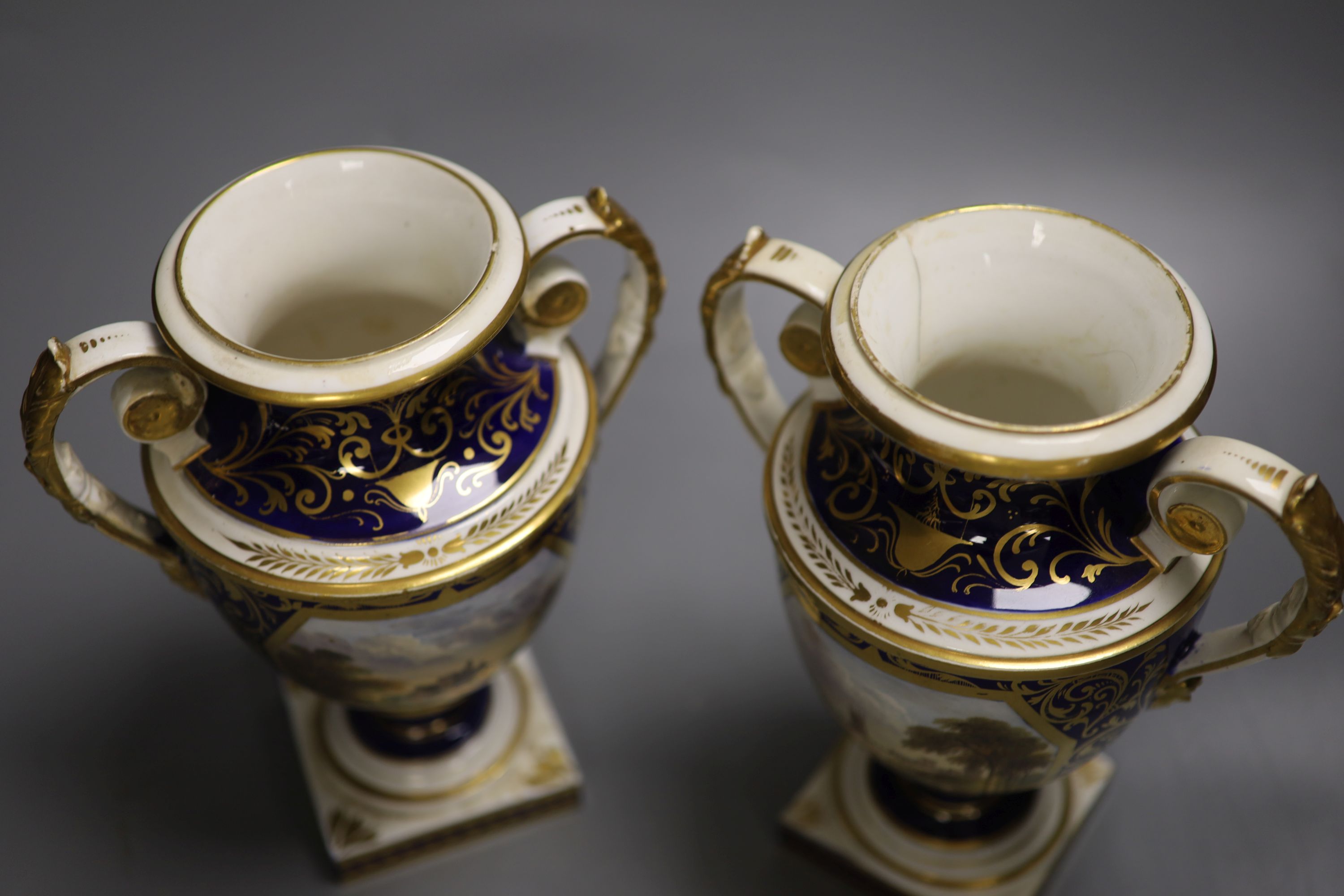 A Derby pair of two handled shield vases, painted with scenes of Old Castle Oxenford and Warwick Castle, height 22cm